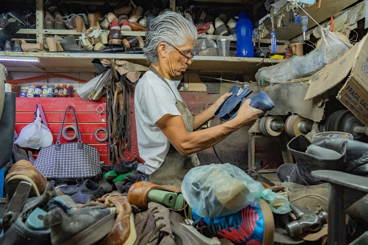 A cobbler working on footwear in a workshop