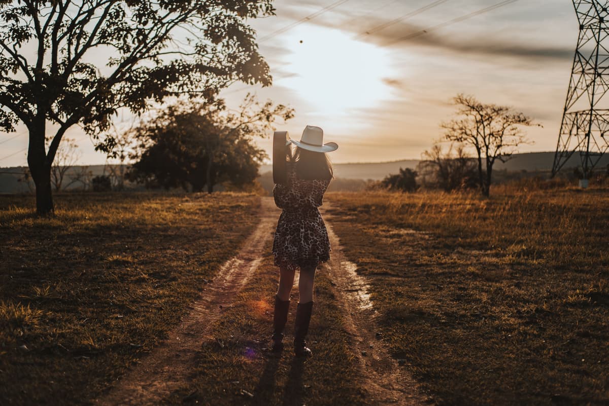 A woman in a dress and western boots outdoors