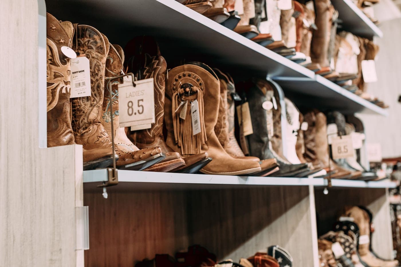 A row of leather cowboy boots on a store shelf
