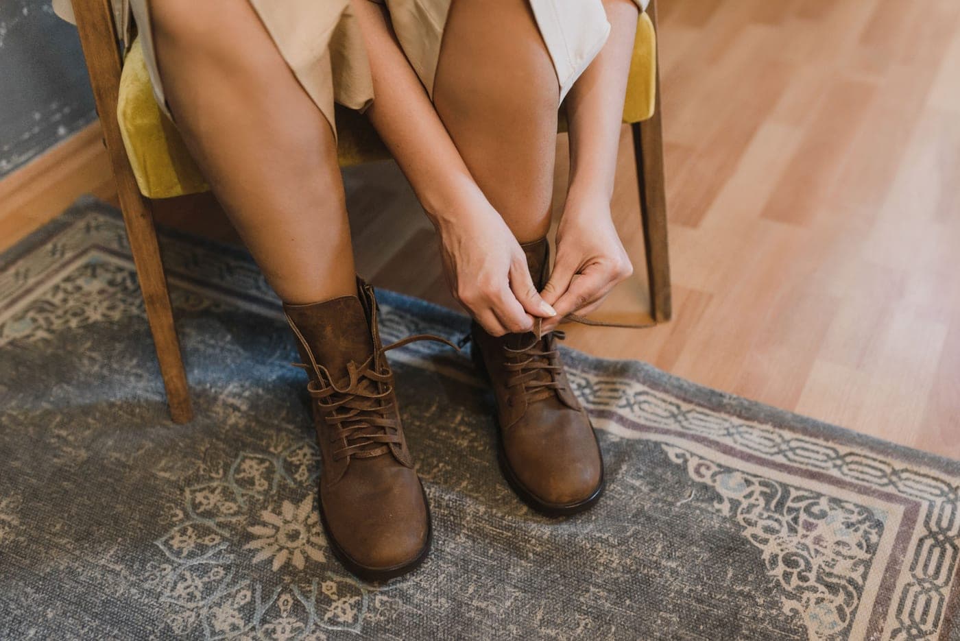 A person pulling on a leather boot